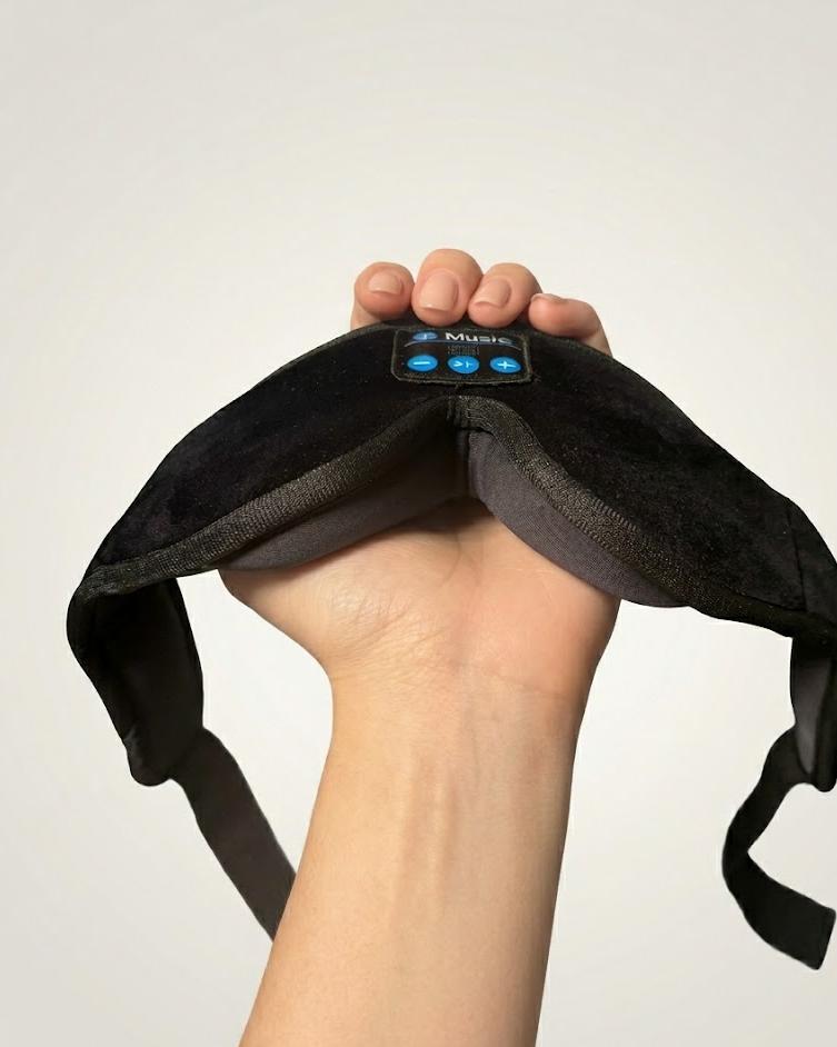 DaySomnia headband held in one hand — plush velvet exterior